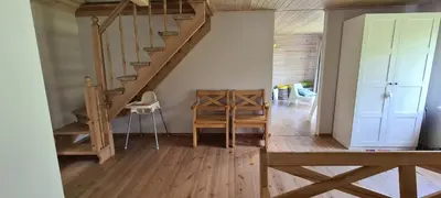 a staircase in a room with a table and a chair at Sodyba Lakaja Sky in Lakaja