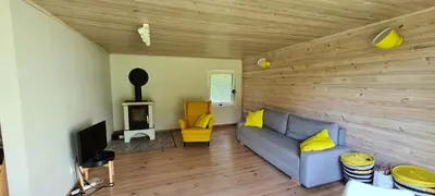 a living room with a blue couch and a television at Sodyba Lakaja Sky in Lakaja