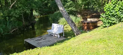 a white chair sitting on a wooden dock next to a river at Sodyba Lakaja Sky in Lakaja