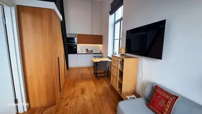 a living room with a couch and a flat screen tv at KaunasInn Loft in Kaunas