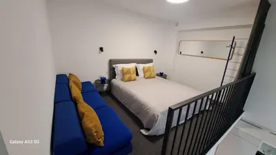 a bedroom with a bed and a blue couch at KaunasInn Loft in Kaunas