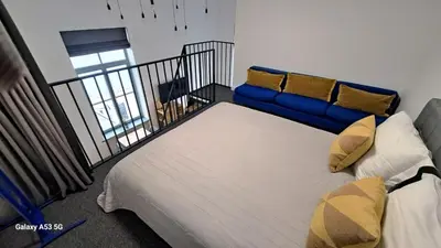 a bed with a blue couch in a room at KaunasInn Loft in Kaunas