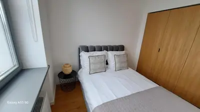 a small bedroom with a bed with white sheets and pillows at KaunasInn Loft in Kaunas
