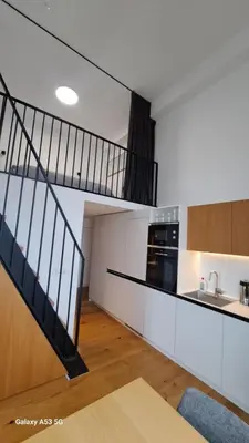 a kitchen with a spiral staircase in a house at KaunasInn Loft in Kaunas