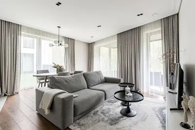 a living room with a couch and a table at Spacious luxury apt w/river view/terrace Paupys in Vilnius