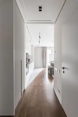 a large white room with a hallway with wooden floors at Spacious luxury apt w/river view/terrace Paupys in Vilnius