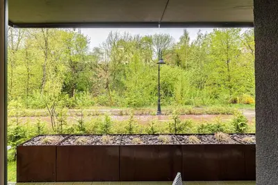 a window view of a garden with a street light at Spacious luxury apt w/river view/terrace Paupys in Vilnius