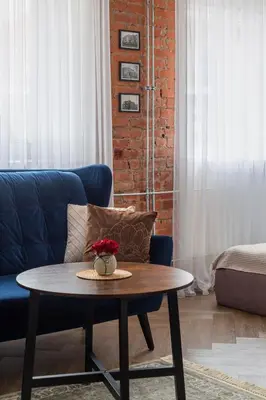 a living room with a blue couch and a table at Old street apartment in Šiauliai