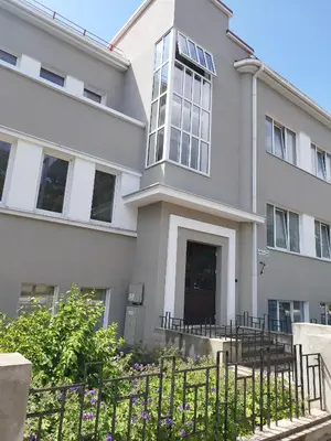a white building with a gate in front of it at Old street apartment in Šiauliai