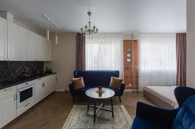 a living room with a bed and a table and chairs at Old street apartment in Šiauliai