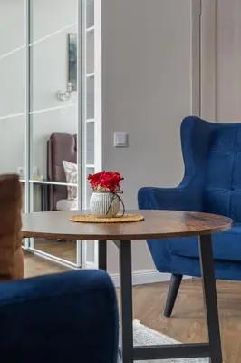 a table with a vase with red flowers on it at Old street apartment in Šiauliai