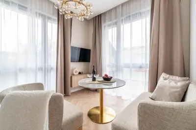 a living room with a chandelier and a table and chairs at Paupys Golden Apartment Vilnius in Vilnius