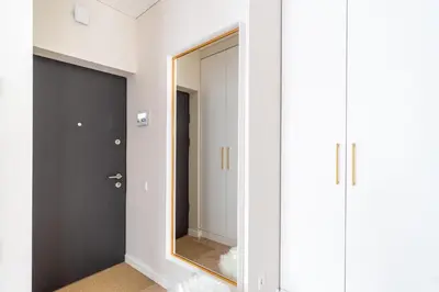 a dressing room with a mirror and a door at Paupys Golden Apartment Vilnius in Vilnius