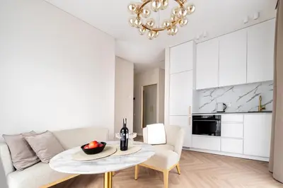 a living room with a table and a couch at Paupys Golden Apartment Vilnius in Vilnius