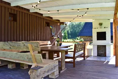 a patio with a wooden table and a fireplace at Pundeliškių sodyba in Šalčininkai