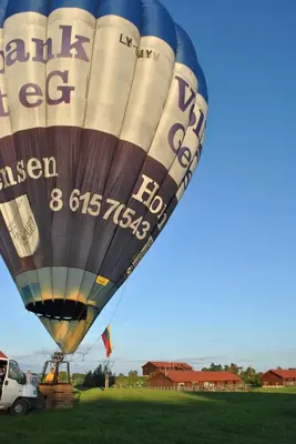 a large hot air balloon flying in the sky at Dvarčėnų dvaras in Dvarčėnai