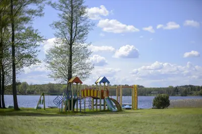 a playground next to a body of water at Dvarčėnų dvaras in Dvarčėnai