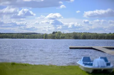 a boat sitting at a dock on a lake at Dvarčėnų dvaras in Dvarčėnai