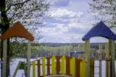 a playground with a view of a body of water at Dvarčėnų dvaras in Dvarčėnai
