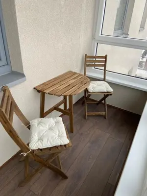 a bench and a table and a chair in a room at Eliana Apartments in Druskininkai