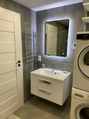 a bathroom with a sink and a washing machine at Eliana Apartments in Druskininkai