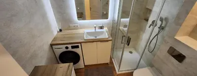 a bathroom with a sink and a washing machine at Golden in Šiauliai