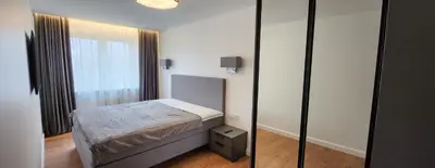 a small bedroom with a bed and a mirror at Golden in Šiauliai