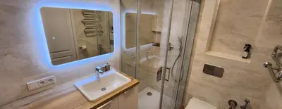 a bathroom with a sink and a shower with a mirror at Golden in Šiauliai