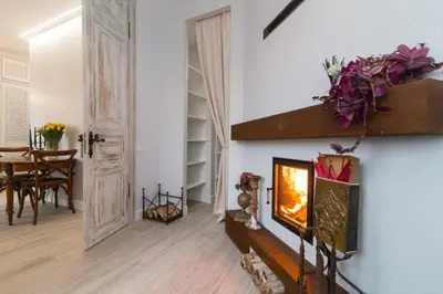 a living room with a fireplace and a dining room at Spectacular river view apartment in Vilnius