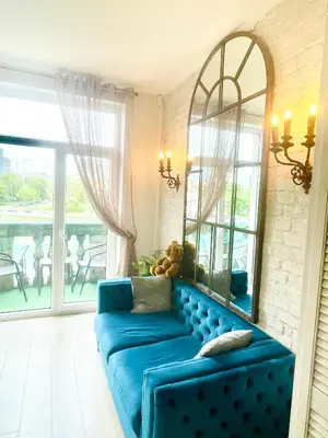 a blue couch in a living room with a mirror at Spectacular river view apartment in Vilnius