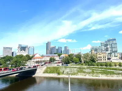 a bridge over a river with a city in the background at Spectacular river view apartment in Vilnius