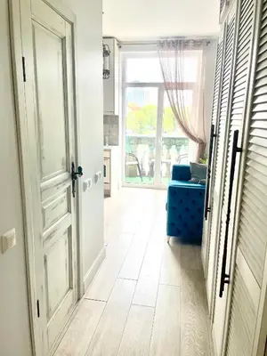 a hallway with a blue couch and a window at Spectacular river view apartment in Vilnius