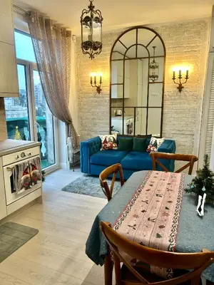 a living room with a blue couch and a table at Spectacular river view apartment in Vilnius