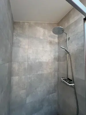 a shower with a shower head in a bathroom at Stripeikių Bitė in Varniškės I