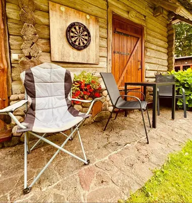 two chairs and a table in front of a cabin at Stripeikių Bitė in Varniškės I