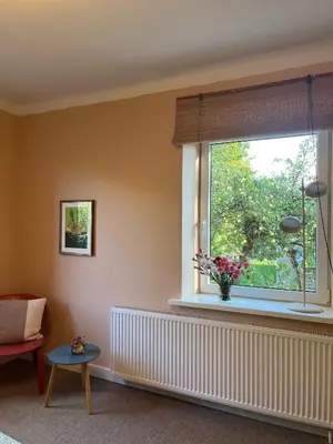 a living room with a window with a vase of flowers at Art&Comfort Country in Kaunas