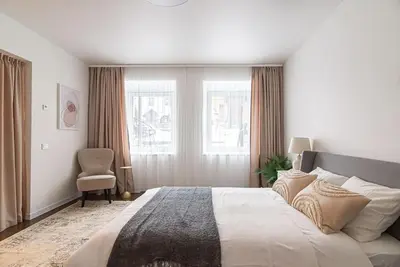 a bedroom with a large bed and a chair at Stylish & Cozy Uzupis Apartment by URBAN RENT in Vilnius