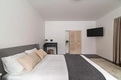 a bedroom with a large bed with a television on the wall at Stylish & Cozy Uzupis Apartment by URBAN RENT in Vilnius