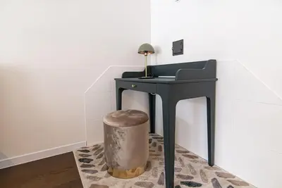 a black table with a stool next to a wall at Stylish & Cozy Uzupis Apartment by URBAN RENT in Vilnius