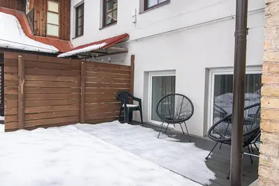 a patio with two chairs and a fence at Stylish & Cozy Uzupis Apartment by URBAN RENT in Vilnius