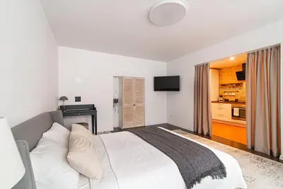 a bedroom with a white bed and a television at Stylish & Cozy Uzupis Apartment by URBAN RENT in Vilnius