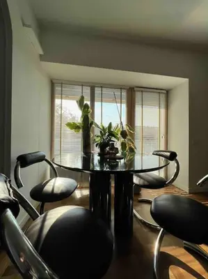 a dining room with a table and chairs and a window at New appartment with art collection in Vilnius