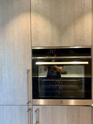 a person is taking something out of an oven at New appartment with art collection in Vilnius