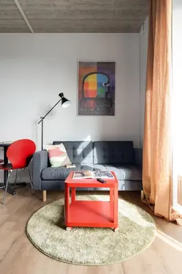 a living room with a red table and a couch at #stayhere - Brand New Colourful Studio close to Shopping Malls in Vilnius