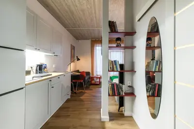 a kitchen with white cabinets and a mirror on the wall at #stayhere - Brand New Colourful Studio close to Shopping Malls in Vilnius