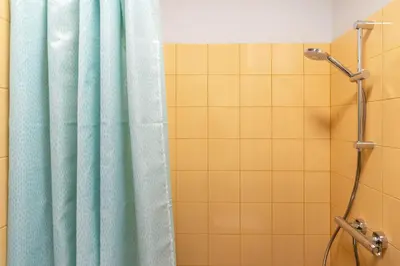 a bathroom with a shower with a blue shower curtain at #stayhere - Brand New Colourful Studio close to Shopping Malls in Vilnius