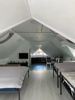 a room with two beds and a table and a tv at „Sėlių Studio“ Apartamentai in Utena