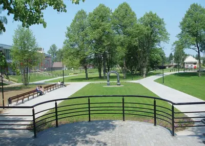 a park with benches and a fountain in a park at „Sėlių Studio“ Apartamentai in Utena