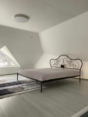 a bed in a white room with a bed frame at „Sėlių Studio“ Apartamentai in Utena