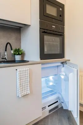 a kitchen with an open refrigerator with a microwave at Frida Elite Apartments in Šiauliai